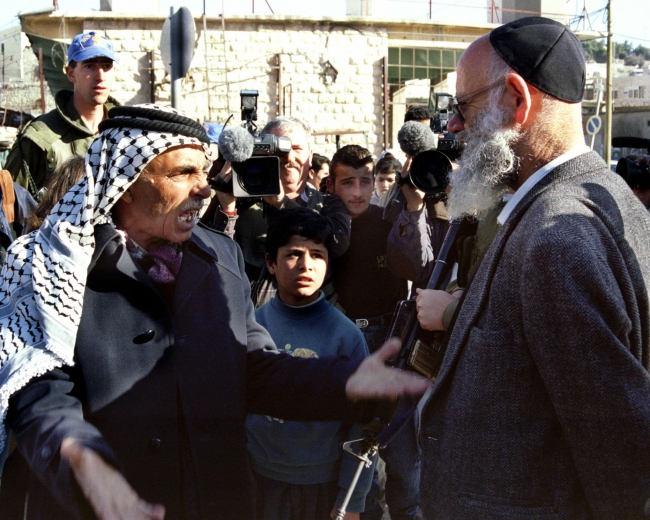 Ünlü sivil Yahudi işgalcilerden Moshe Levinger ve bir Filistinli, El-Halil, 1997. Fotoğraf: Reuters